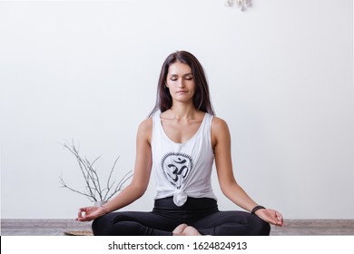 Relaxed Harmonious Beautiful Brunette Woman Yoga Instructor Doing Lotus Position. Closed Eyes, Mudra Gesture, Sitting On Rug On Floor During Workout. Health And Spirit Improvement Concept. Copyspace