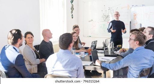 Relaxed informal IT business startup company meeting. Team leader discussing and brainstorming new approaches and ideas with colleagues. Startup business and entrepreneurship concept. - Shutterstock ID 796315264