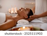 Relaxed lady receiving head massage from professional masseur, resting at modern luxury spa in calm and serene atmosphere, side view