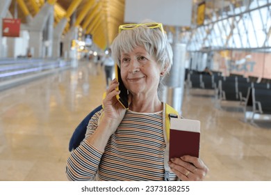 A relaxed looking senior female traveler is getting good news on the phone - Shutterstock ID 2373188255