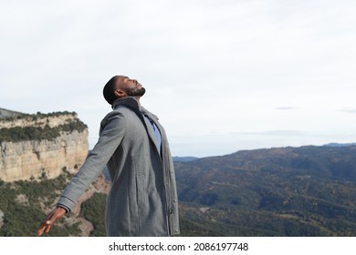 Relaxed Man With Black Skin Breathing Fresh Air Wearing Jacket In Winter In Nature