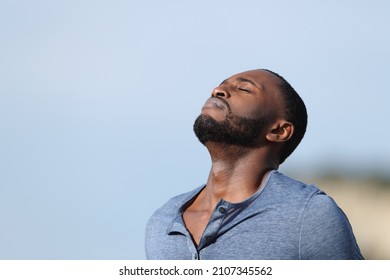 Relaxed Man With Black Skin Breathing Fresh Air Outside In The Mountain