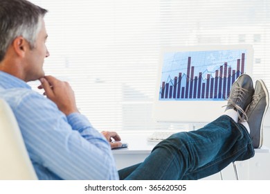 Relaxed Man With Feet On Desk Using Computer Against Blue Data