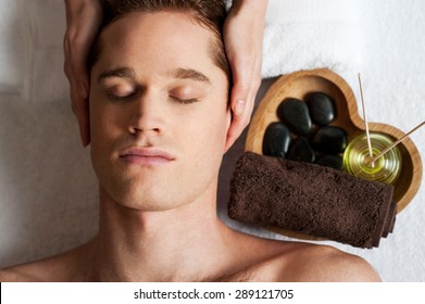 Relaxed Man Getting A Face  Massage At Day Spa