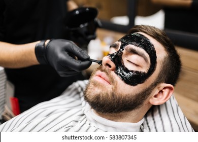 Relaxed man having purifying mask on face