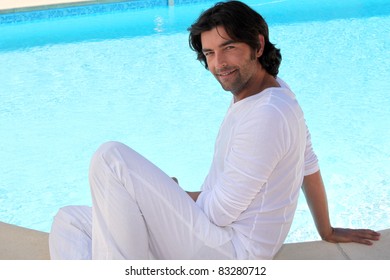 Relaxed man sitting at the poolside