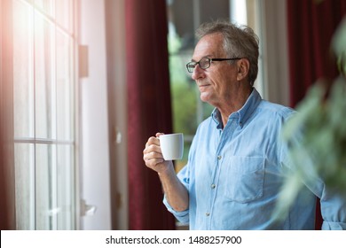 Relaxed mature man at home standing by the window
 - Powered by Shutterstock