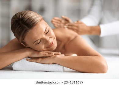 Relaxed Middle Aged Woman Getting Therapeutic Manual Massage In Wellness Center, Calm Beautiful Mature Female Lying On Table With Closed Eyes, Enjoying Body Treatment In Spa Salon, Closeup Shot - Powered by Shutterstock