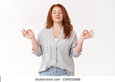 Relaxed Middle-aged Carefree Redhead Woman Exercise Yoga Breathing Practice Gather Patience Release Stress Smiling Close Eyes Inhale Fresh Air Standing Lotus Nirvana Zen Pose Meditating Happily