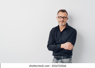 Relaxed middle-aged man wearing glasses standing with folded arms over a white background looking at the camera - Powered by Shutterstock