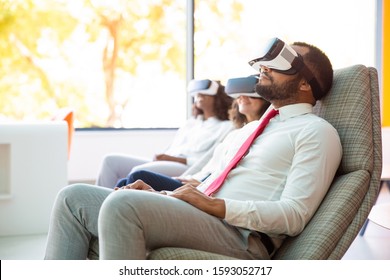 Relaxed multiethnic business colleagues in VR headsets. Group of professional business people in formal wear sitting and using virtual reality headsets in office. Technology concept - Powered by Shutterstock