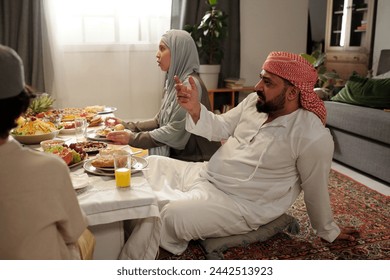 Relaxed Muslim Man Taking Part In Conversation During Dinner - Powered by Shutterstock