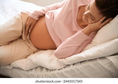 Relaxed pregnant woman on bed in hospital ward during antenatal examination - Powered by Shutterstock