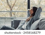 Relaxed serene pretty young woman feel fatigue lounge on comfortable sofa hands behind head rest at home, happy calm lady dream enjoy wellbeing breathing fresh air in cozy home modern living room