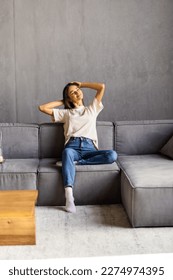 Relaxed serene pretty young woman feel fatigue lounge on comfortable sofa hands behind head rest at home, happy calm lady dream enjoy wellbeing breathing fresh air in cozy home modern living room - Shutterstock ID 2274974395