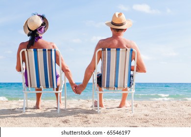 Relaxed summer vacation senior couple of old man and woman sitting on the beach