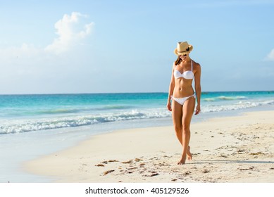 Relaxed Woman In Bikini Enjoying Tropical Beach And Caribbean Summer Vacation. Fit Tanned Brunette Enjoying A Walk By The Sea At Playa Paraiso, Riviera Maya, Mexico.