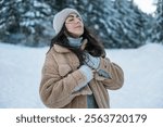 Relaxed woman breathing fresh air in a snowy winter mountain