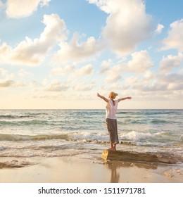 Relaxed woman enjoying sun, freedom and life an beautiful beach in sunset. Young lady feeling free, relaxed and happy. Concept of vacations, freedom, happiness, enjoyment and well being. - Shutterstock ID 1511971781