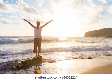 Relaxed woman enjoying sun, freedom and life an beautiful beach in sunset. Young lady feeling free, relaxed and happy. Concept of vacations, freedom, happiness, enjoyment and well being. - Powered by Shutterstock