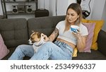 A relaxed woman enjoys coffee on a couch with her dog in a cozy, modern living room.