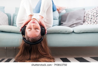 Relaxed woman with headphones on sofa at home listening music - Shutterstock ID 793813750