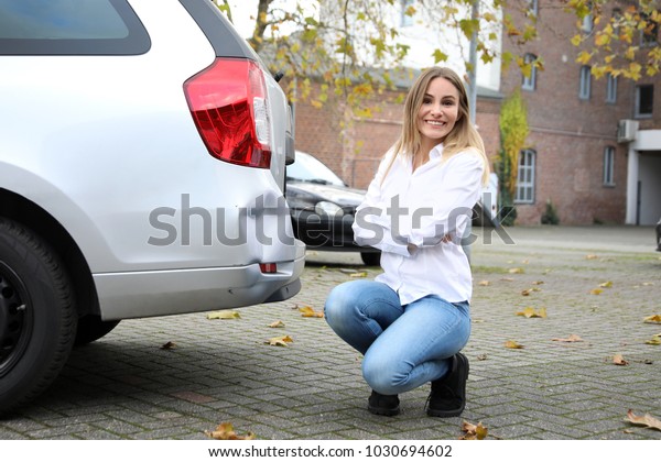 Relaxed woman with her damaged\
car