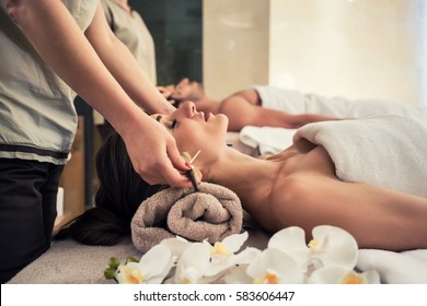 Relaxed Woman Lying Down On Massage Bed During Facial Treatment At Asian Spa And Wellness Center