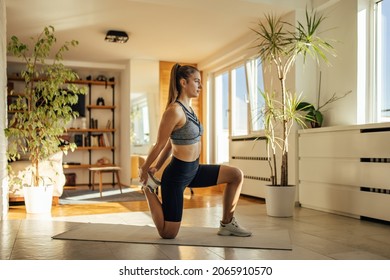 Relaxed woman, pulling her leg, to better stretch her quadriceps