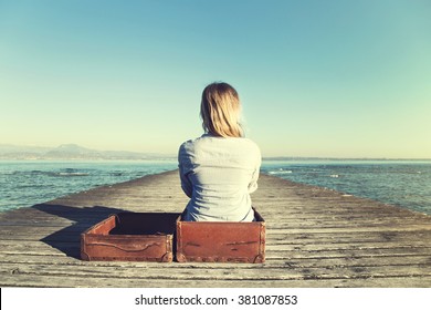 Relaxed Woman Sitting In Her Big Suitcase After A Long Journey