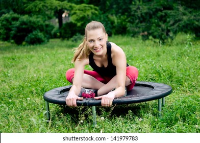 Relaxed Woman Sitting On Mini Trampoline