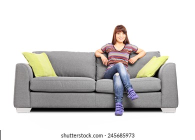 Relaxed Woman Sitting On A Modern Sofa Isolated On White Background