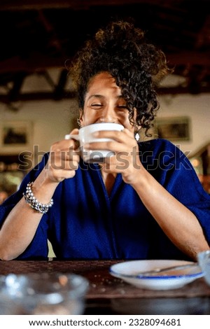 Relaxed woman smiling and drinking a cup of coffee