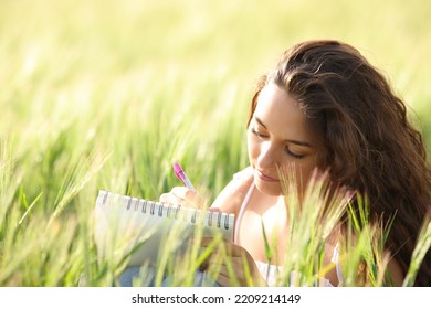 Relaxed Woman Taking Notes Or Drawing On Notebook In A Field