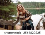 Relaxed woman tourist enjoying nature, breathing fresh air on the lake. Solitude with nature. Active lifestyle.