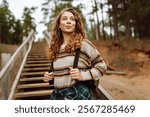 Relaxed woman tourist enjoying nature, breathing fresh air on the lake. Solitude with nature. Active lifestyle.