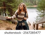 Relaxed woman tourist enjoying nature, breathing fresh air on the lake. Solitude with nature. Active lifestyle.