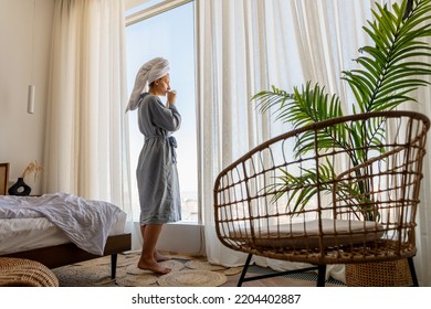 Relaxed Woman Wearing Bath Robe Drinking Coffee In Hotel Room In Morning