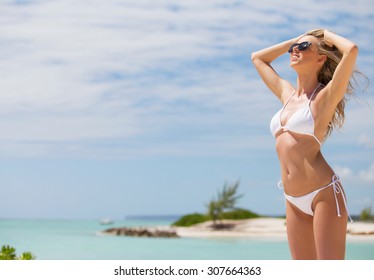 Relaxed woman in white bikini on the beach