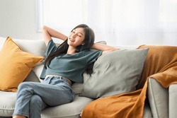 Relaxed Young Asian Woman Enjoying Rest On Comfortable Sofa At Home, Calm Attractive Girl Relaxing And Breathing Fresh Air In Home, Copy Space.