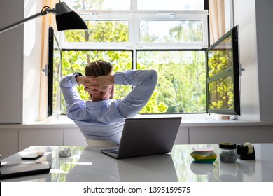 Relaxed Young Businessman Relaxing On Chair Behind Desk At Office - Powered by Shutterstock