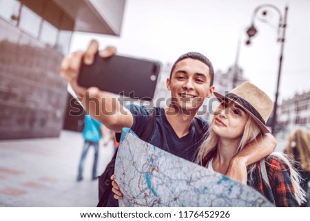 Similar – couple taking selfie in the street