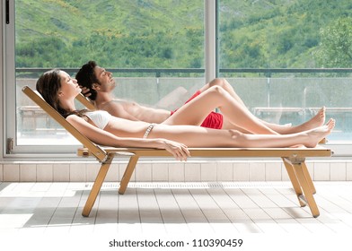 Relaxed young couple sunbathing on sunbeds in the nature - Powered by Shutterstock