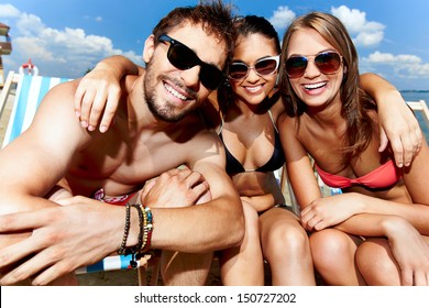 Relaxed Young Friends Having Rest On The Beach