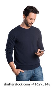 Relaxed Young Man In Casual Typing Message On Smartphone. Portrait Of A Happy Man Using Cell Phone Isolated On White Background. Handsome Guy Checking Mail. Communicaton And Connection Concept.
