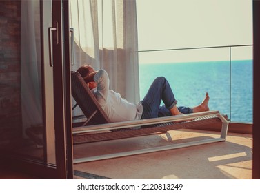 Relaxed young man at home on the balcony. Holiday and travel concept