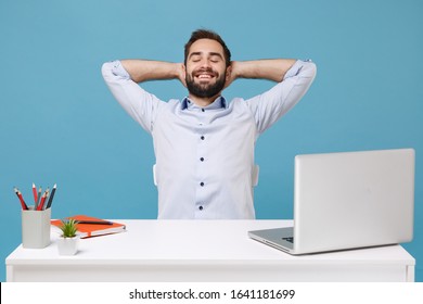 Relaxed Young Man In Light Shirt Sit Work At Desk With Pc Laptop Isolated On Pastel Blue Background. Achievement Business Career Lifestyle Concept. Keeping Eyes Closed Sleeping With Hands Behind Head