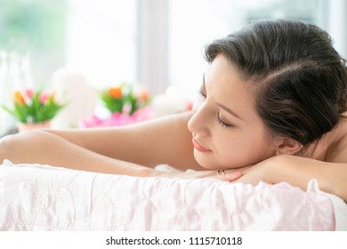Relaxed young woman lying on spa bed prepared for massage treatment in luxury spa resort. Wellness, stress relief and rejuvenation concept. - Shutterstock ID 1115710118