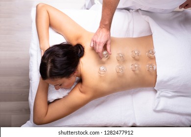 Relaxed Young Woman Receiving Cupping Treatment On Her Back In Spa