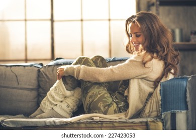 Relaxed Young Woman Sitting In Loft Apartment